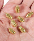 Eight 0.6mm MK8 Extruder Nozzles for 3D Printers, High Quality Replacement Nozzles, held in hand