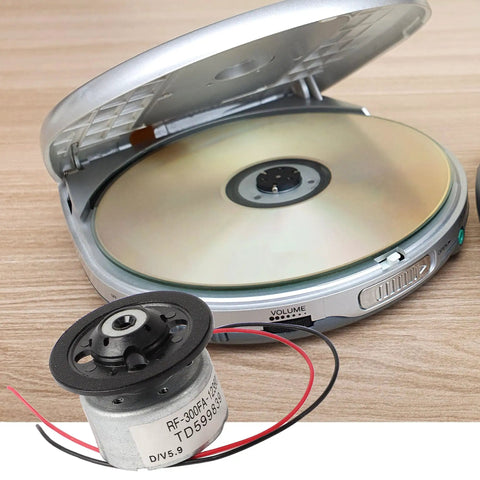 DC Five Point Nine Volt Spindle Motor For DVD CD Players With Metal RF300FA12350 beside open CD player with disc