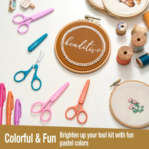 Two Piece High Precision Detail Scissors Set With Sharp Fine Tips in Pastel Purple and Pink with crafting supplies on table.