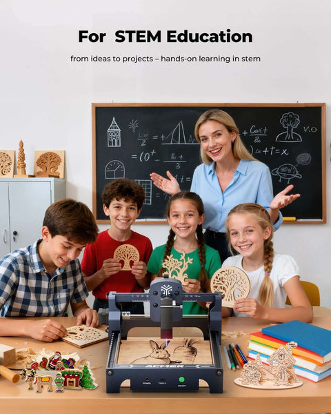 Front view: ACMER S1 laser engraver on a desk in a classroom; dark-gray machine with students holding wooden cutouts.