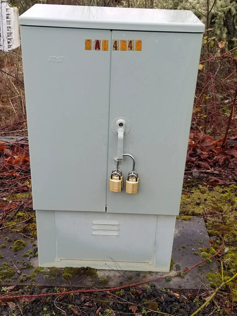 Heavy Duty Multi User Padlock Holder Provides Solid Gate Or Door Security Supports Four Independent Keys Ditch The Chain Link Hassle For A Top Shelf Setup Today on a grey storage unit with two padlocks.