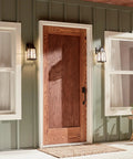 Tolerand 12 Inch Outdoor Wall Light In Textured Black With Clear Seeded Glass highlighting porch entryway at night