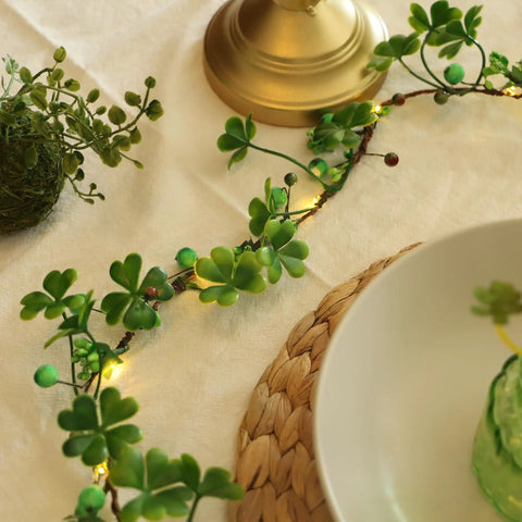 Close-up of green leaf fairy lights on table, entwined with tiny LED bulbs.