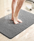 Super Chill Non Slip Shower Mat With Quick Dry Drain Holes And Sticky Traction Phthalate Free PVC Bathroom Must Have Quick Drying Loofah Texture Grey 24X16 Inches Plus Drain, person standing on mat in shower.