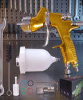 Smooth Operator Gold Toned Pneumatic Hvlp Paint Spray Gun With 1.3Mm And 1.8Mm Stainless Steel Nozzles and 600Ml cup displayed with accessories.