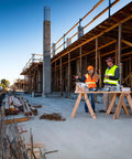 Construction site with workers inspecting Titen HD Screw Anchor boxes, used for concrete and masonry.