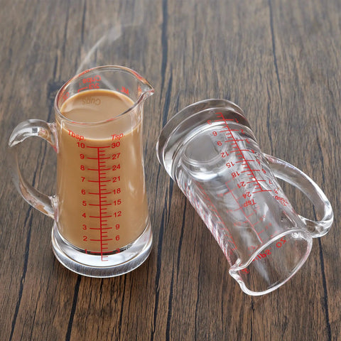 Glass Measuring Cup 5 Oz 150 Ml Shot Glass With V Spout And Insulated Handle shown filled and empty on wooden surface