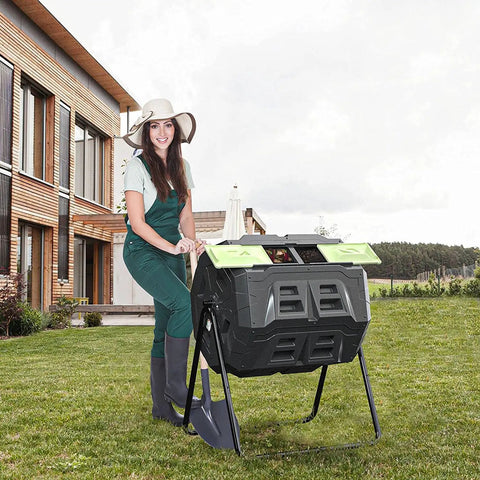 Woman using a 43 Gallon Outdoor Tumbler Compost Bin With Dual Compartment Design Rotating Garden Composter For Efficient Aeration And No Fuss Two Step Composting Green Door on a lawn.