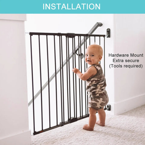 Easy Swing and Lock Baby Gate Series 2 hardware mounted, matte bronze finish at top of stairs, toddler standing nearby.