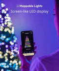 65.6 Feet Indoor Outdoor Smart RGB LED String Lights With Over 16 Million Dope Colors App Control HomeKit Alexa Google Home Compatible IP44 Weatherproof Customizable Effects Black Wire 250 LEDs with app control in use by a person.