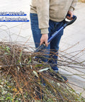 Person using Heavy Duty Garden Fork With Fiberglass Handle 43 Inches Long 4 Tines For Digging Composting Spading Yard Work Weeding Durable Pitchfork For Garden Beds to clear weeds and branches.
