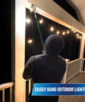 Person using 36 inch reacher grabber tool to hang outdoor lights on porch at night