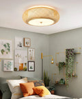 Handwoven Bamboo Drum Flush Mount Ceiling Light With Rattan Shade 3 Light Boho Fixture illuminating a cozy bedroom.