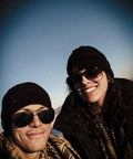 Couple wearing Cotton Shemagh Keffiyeh Tactical Desert Scarf Neck Head Wrap With Tassel, smiling outdoors in winter attire