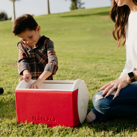 Child using Playmate Elite Red Cooler With One Hand Opening Button Spill Proof Locking Lid Built In Carry Handle outdoors