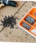 100 Piece Mini Machine Screws For Furniture Repair And DIY Projects on a workshop surface with assorted fasteners in a container.
