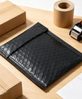 100 Pack 5 By 6 Inch Black Poly Bubble Mailers Self Seal Padded Envelopes Waterproof Shipping Bags on desk with packaging supplies
