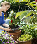 Gardener using Heavy Duty Garden Trowel With Ergonomic Non Slip Grip Rust Resistant Finish for planting in a pot