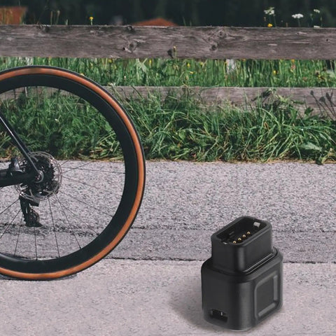 USB-C To 4-Pin Charger Adapter For 12-Speed Electronic Derailleurs And Type-C Converter Cable next to bike wheel