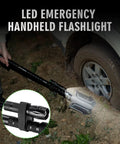 28-In-1 Survival Shovel Set With Axe And Knife used to dig beside a car tire at night, illuminated by LED flashlight