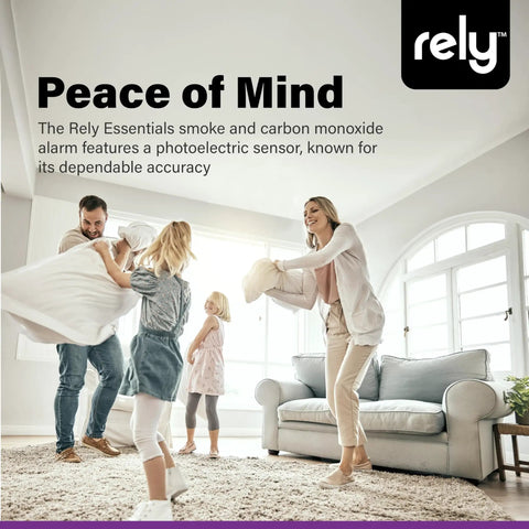 Family playing in living room, advertisement for 5600 Smoke And Carbon Monoxide Alarm With Hardwired Power And Battery Backup.