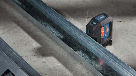 Green Beam Self Leveling Alignment Laser Pro Grade With Plumb And Level Point Projection next to metal beam on floor