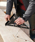 Craftsman using Dead On Twelve Inch Aluminum Rafter Square Top Shelf Carpenter Triangle Ruler for marking wood angle.