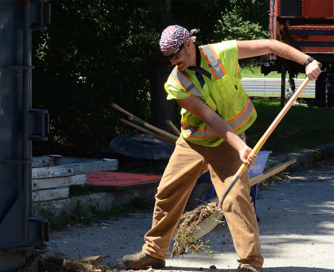 Outdoor worker wearing Original MiraCool 940 Cooling Neck Bandana in assorted colors, shoveling, suitable for heat relief during hustle sports.