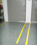 Heavy Duty Polyester Floor Marking Tape In Bright Yellow, 2 Inch by 100 Foot Roll, applied as lane markers on warehouse floor.