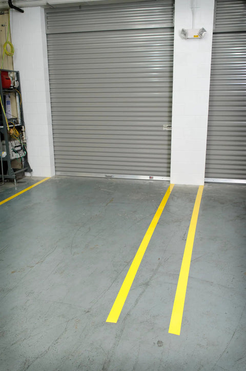 Heavy Duty Polyester Floor Marking Tape In Bright Yellow, 2 Inch by 100 Foot Roll, applied as lane markers on warehouse floor.
