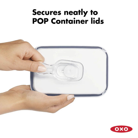 Clear Coffee Scoop For POP Storage Containers, 2 Tbsp 30 mL Capacity, fits under lid held by hands showing attachment.