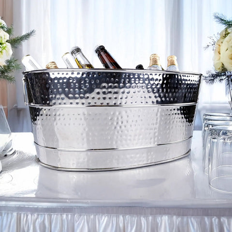 Aspen Heavy-Duty Oval Stainless Steel Drink Cooler For Parties 25-Quart Large Ice Bucket with bottles on a table