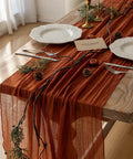Rustic Fall Thanksgiving Table Runner Terracotta Cheesecloth Weave 120 Inches Long Hand Dyed Soft Cotton Gauze on a wooden table.