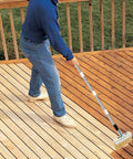 Person using All In One Deck Stain Brush Kit with 67 Inch Extendable Handle on wooden deck
