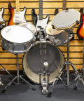 Ultimate Tall Snare Drum Stand With Stick Holder For Kids And Adults Adjustable Height From 26 To 40 Inches Double Braced Stability Fits 10-14 Inch drums, silver finish with surrounding guitars.