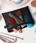 Black Nylon Mesh Zipper Pouches Set Of Five See Through Travel Organizer Bags with cosmetics and brushes on table