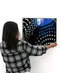 Person hanging a framed picture using Badass Heavy Duty Picture Hangers With Tough Aluminum Grip on a white wall.