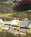 Portable Patio Umbrella With Solid Clamp Mount For Beach Chairs And Golf Carts, No Fuss Manual Open Close, Heavy Duty Sunshade Delivers Top Shelf UV Block And Swift 360 Swivel Base For Laidback Outdoor Chill Days (43 Inch Wine) mounted on a beach chair by a serene lake.