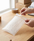 Self-Seal Cushion Wrap Pouches 8x4 Inch Double-Walled Bubble Bags for Shipping and Packing Supplies being sealed by hand
