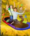 Children enjoying 66 Inch Oval Saucer Swing For Kids And Teens Outdoor Indoor Backyard Fun With Adjustable Ropes Durable Seat Supports Up To 700 Pounds Includes Safety Net in a sunny backyard.