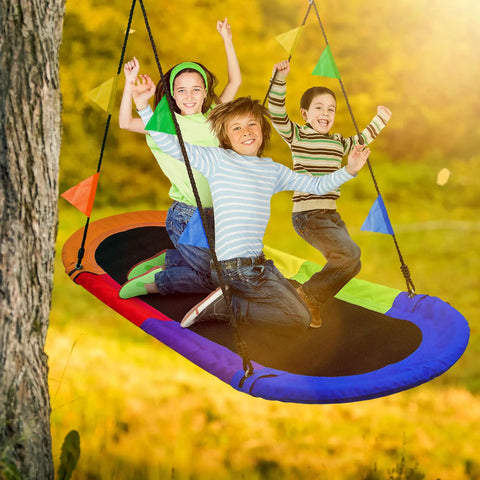 Children enjoying 66 Inch Oval Saucer Swing For Kids And Teens Outdoor Indoor Backyard Fun With Adjustable Ropes Durable Seat Supports Up To 700 Pounds Includes Safety Net in a sunny backyard.