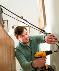Man using drill to install TV and Furniture Safety Straps 53 Inch Long Universal Mounting Straps for TVs to Wall or Furniture 2 Pack