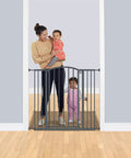 Woman with children by Extra Tall Decor Safety Gate For Kids And Pets In Gray Fits Openings From 28 To 38.25 Inches Wide And 36 Inches High