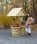 Person beside a six foot octagon wishing well featuring cedar shingle roof, designed from Top Shelf DIY Woodworking Plans For A Six Foot Octagon Wishing Well Featuring Cedar Shingle Roof And Slick Rustic Yard Charm With Dead Simple Step By Step Photo Manual And Rock Solid Build Specs.