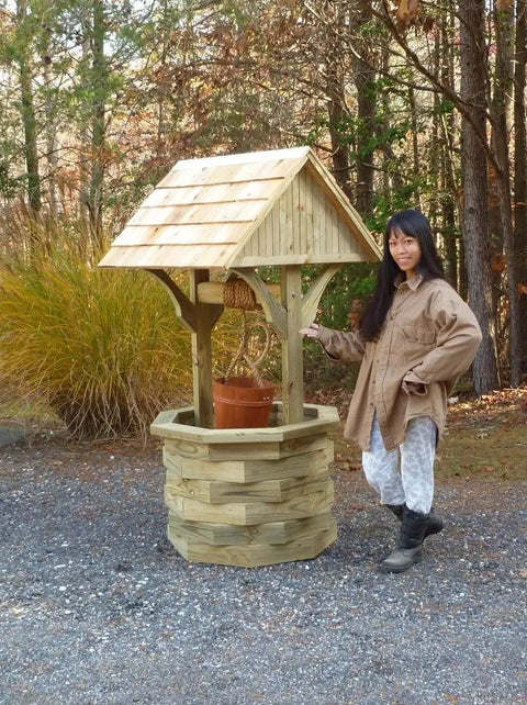 Person beside a six foot octagon wishing well featuring cedar shingle roof, designed from Top Shelf DIY Woodworking Plans For A Six Foot Octagon Wishing Well Featuring Cedar Shingle Roof And Slick Rustic Yard Charm With Dead Simple Step By Step Photo Manual And Rock Solid Build Specs.
