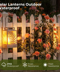 Outdoor Solar Lanterns With Flickering Flame 2 Pack Rustproof Metal LED Lights illuminating a garden fence in rain.