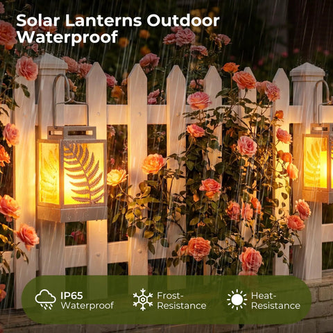 Outdoor Solar Lanterns With Flickering Flame 2 Pack Rustproof Metal LED Lights illuminating a garden fence in rain.