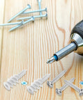 Heavy Duty Self Drilling Drywall Anchors And Screws Kit with drill on wooden surface, nylon and iron components visible