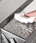 Close-up of a Sturdy Stainless Steel Toolbox With Multi Layer Lockable Cabinet And Handy Carry Handle For Home And Garage Tools Durable Rust Resistant Organizer With water droplets being wiped by hand.
