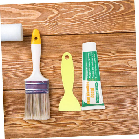 Drywall Repair Putty Paste For Quick Hole Patching And Wall Mending Cream tube with brush and spatula on wood surface